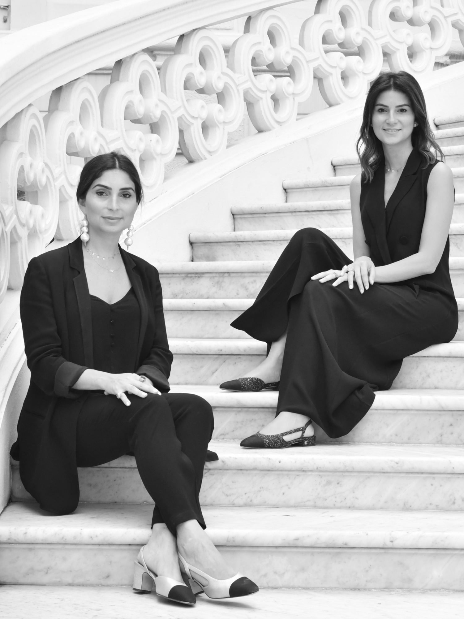 two sisters who are sitting on the stairs Nour and Maysa Saccal represent Saccal Design. The company provides interior design and architecture services as well as product design.